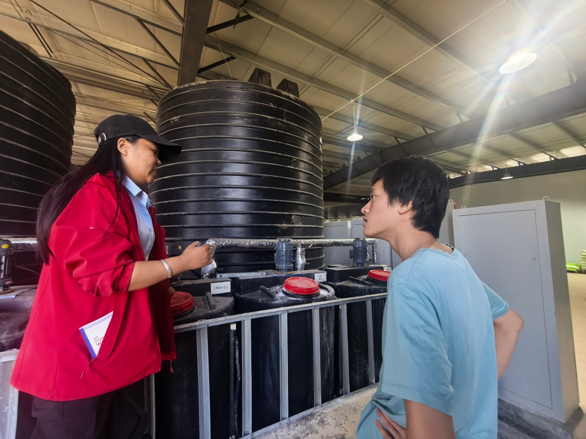 Daniel discussing fertilizer production equipment with a site worker