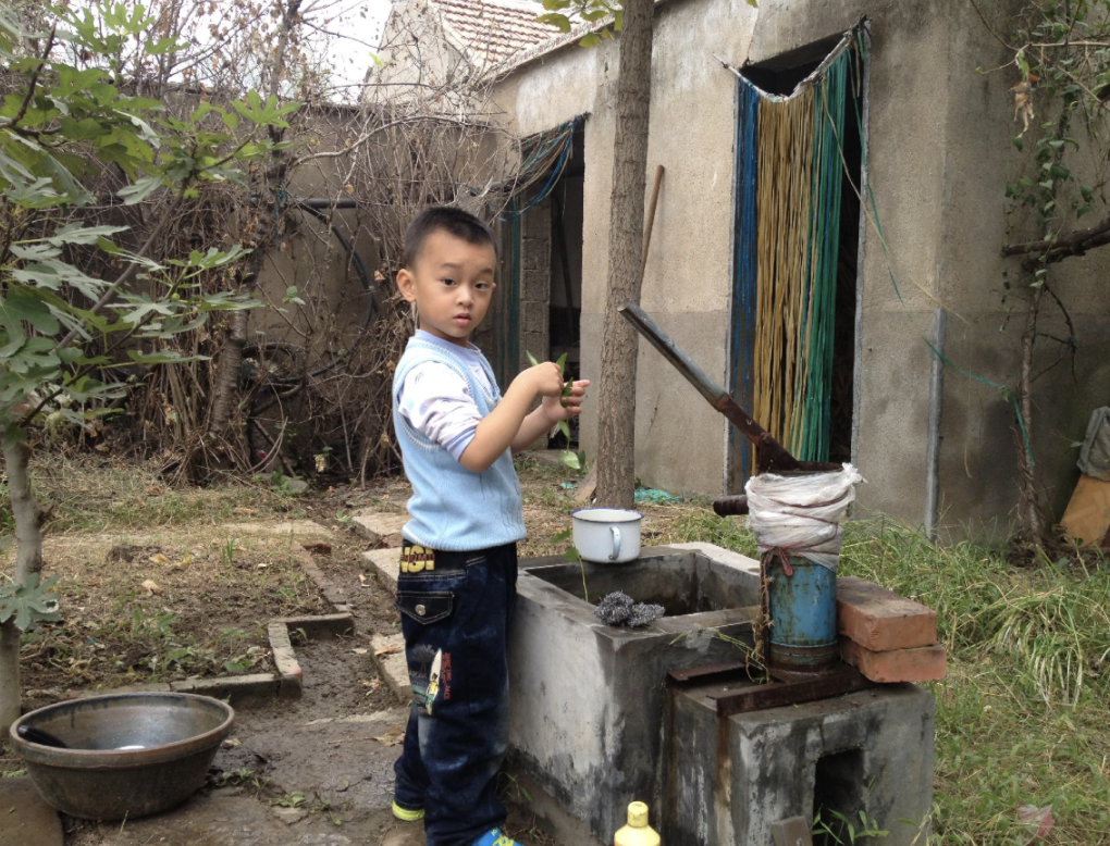 Young Daniel pumping water for courtyard vegetables