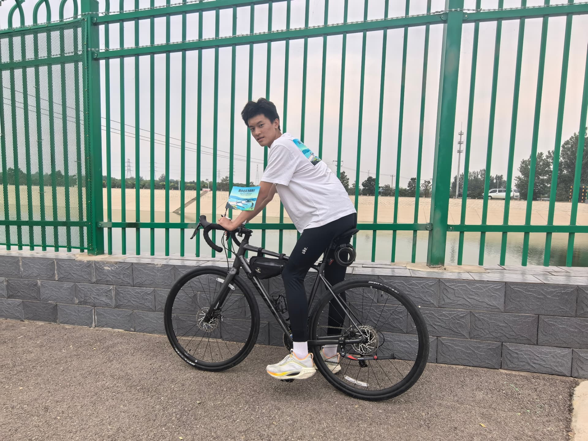 Daniel standing with his road bike during a reservoir ride