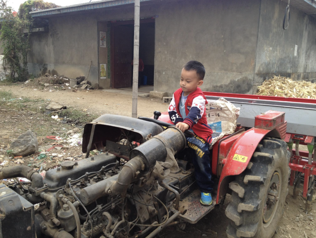 Young Daniel sitting on his grandfather's tractor